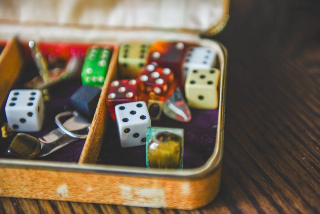 Boîte ancienne contenant des dés, une bague et de petits objets posée sur une table en bois
